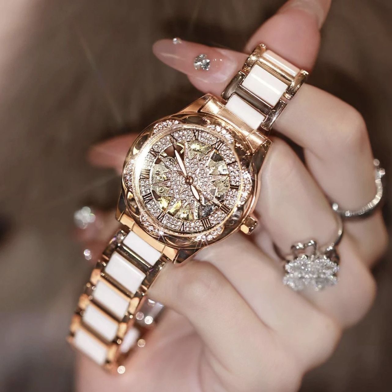 O1CN01VeWzhN2NjbLg9bhM8_2209482079999-0-cib.jpg A generation of shaking audio and video number explosions sunflower hollow ladies watch ceramic white flywheel diamond watch women - Image 1